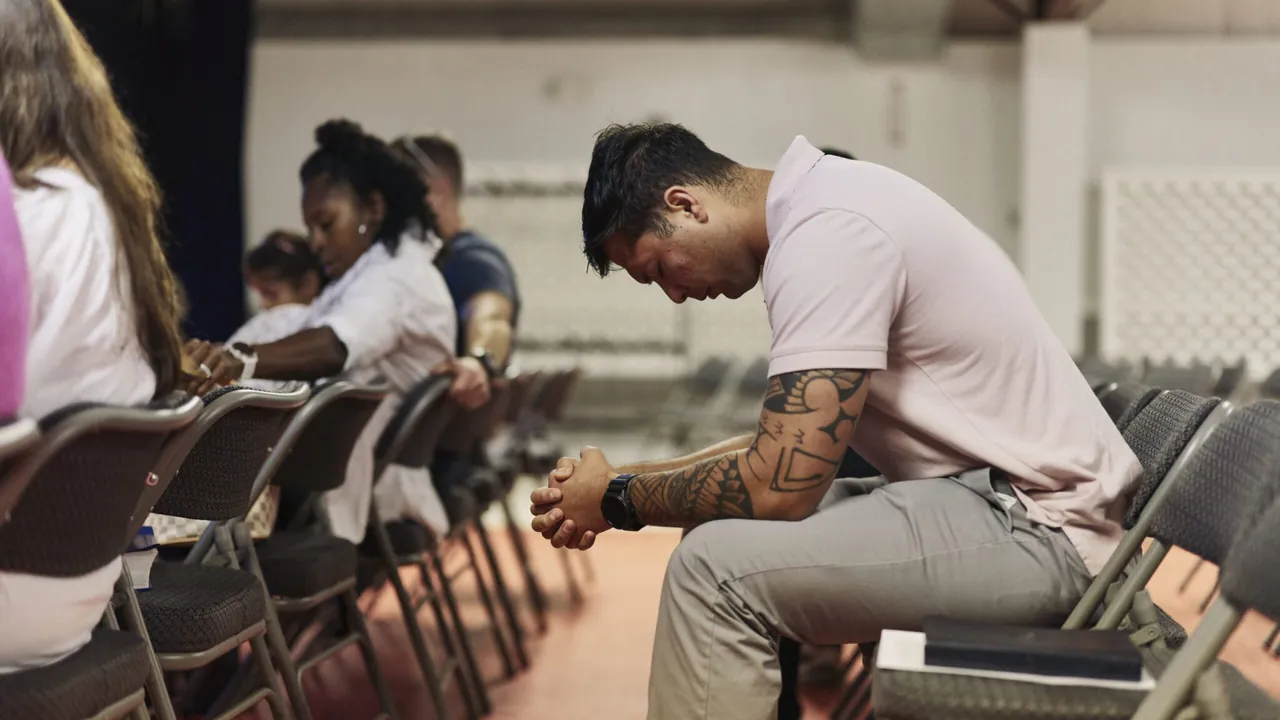 A participant praying during a church gathering